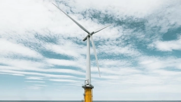 Offshore wind turbine with yellow monopile base in open water
