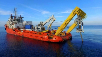 Red offshore support vessel with yellow A-frame deployment structure extended over stern